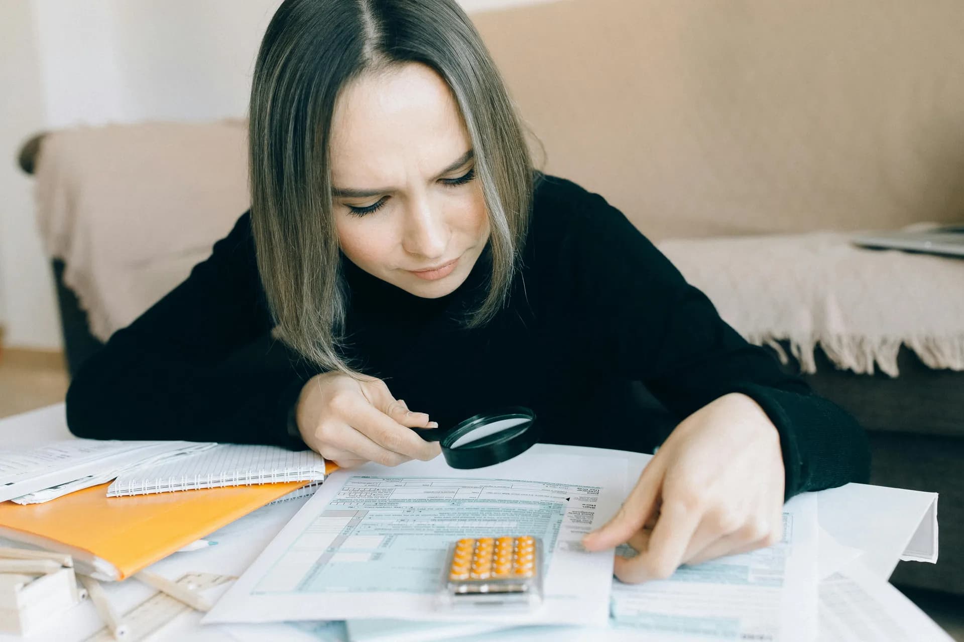 Auditor reviewing financial documents with magnifying glass