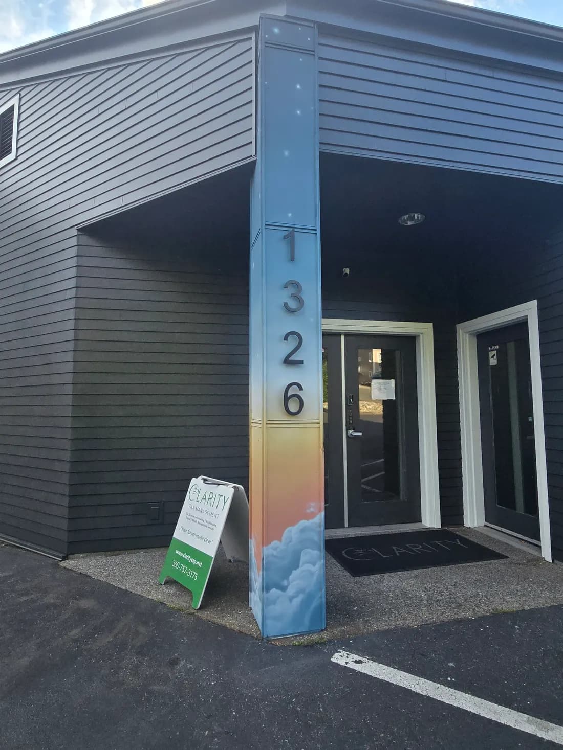 Front door of the Clarity Tax & CPAs Bellingham office with the Clarity sandwich board and branded entry mat