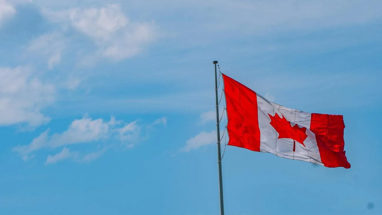 A Canadian flag against a clear sky