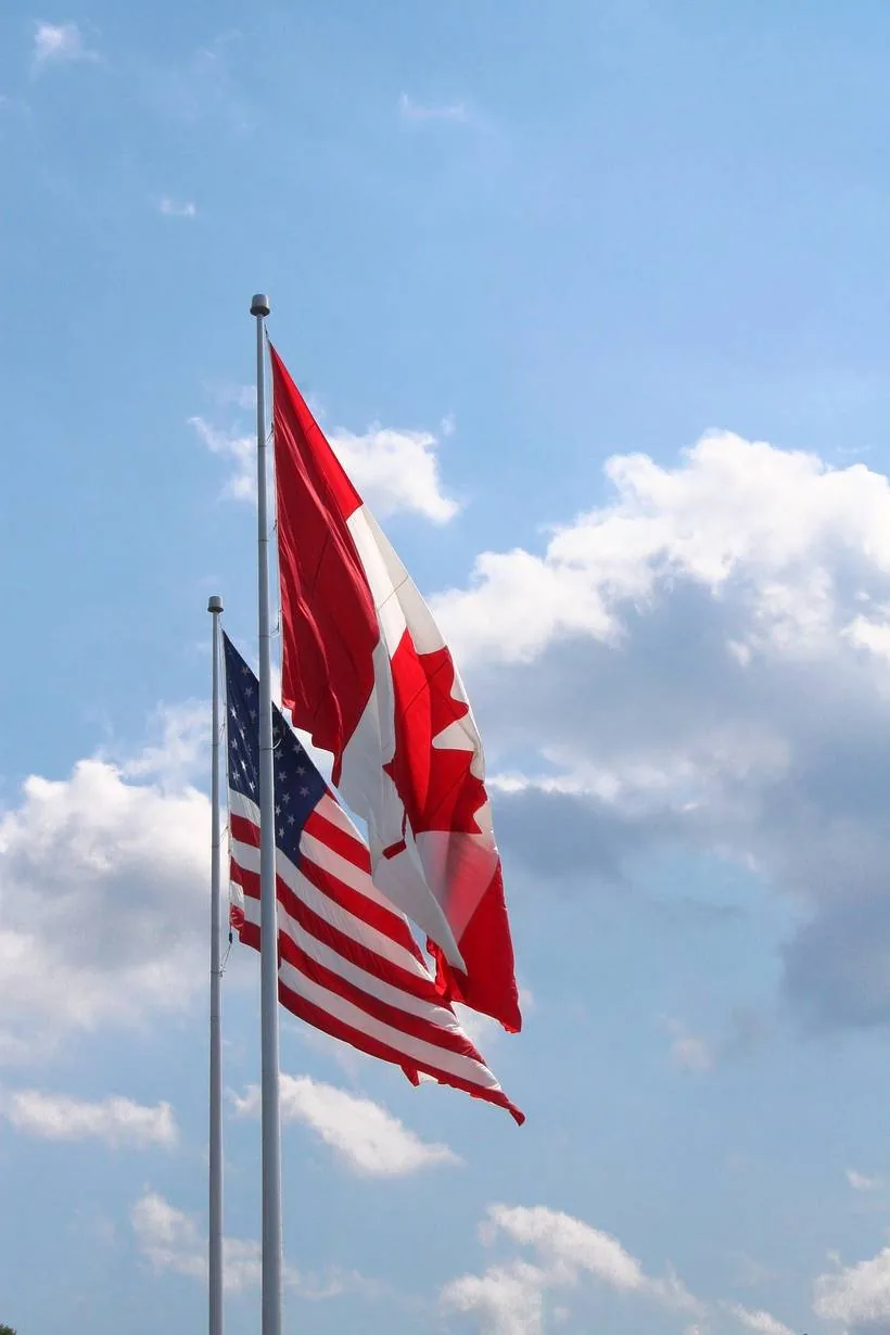 American and Canadian flags flying side by side